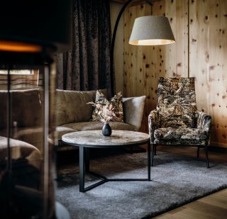 Rieser - Zimmer Fauteuil mit Junglestoff, Beistelltisch mit Marmoroberfläche, Sofa, Teppich dunkelgrau